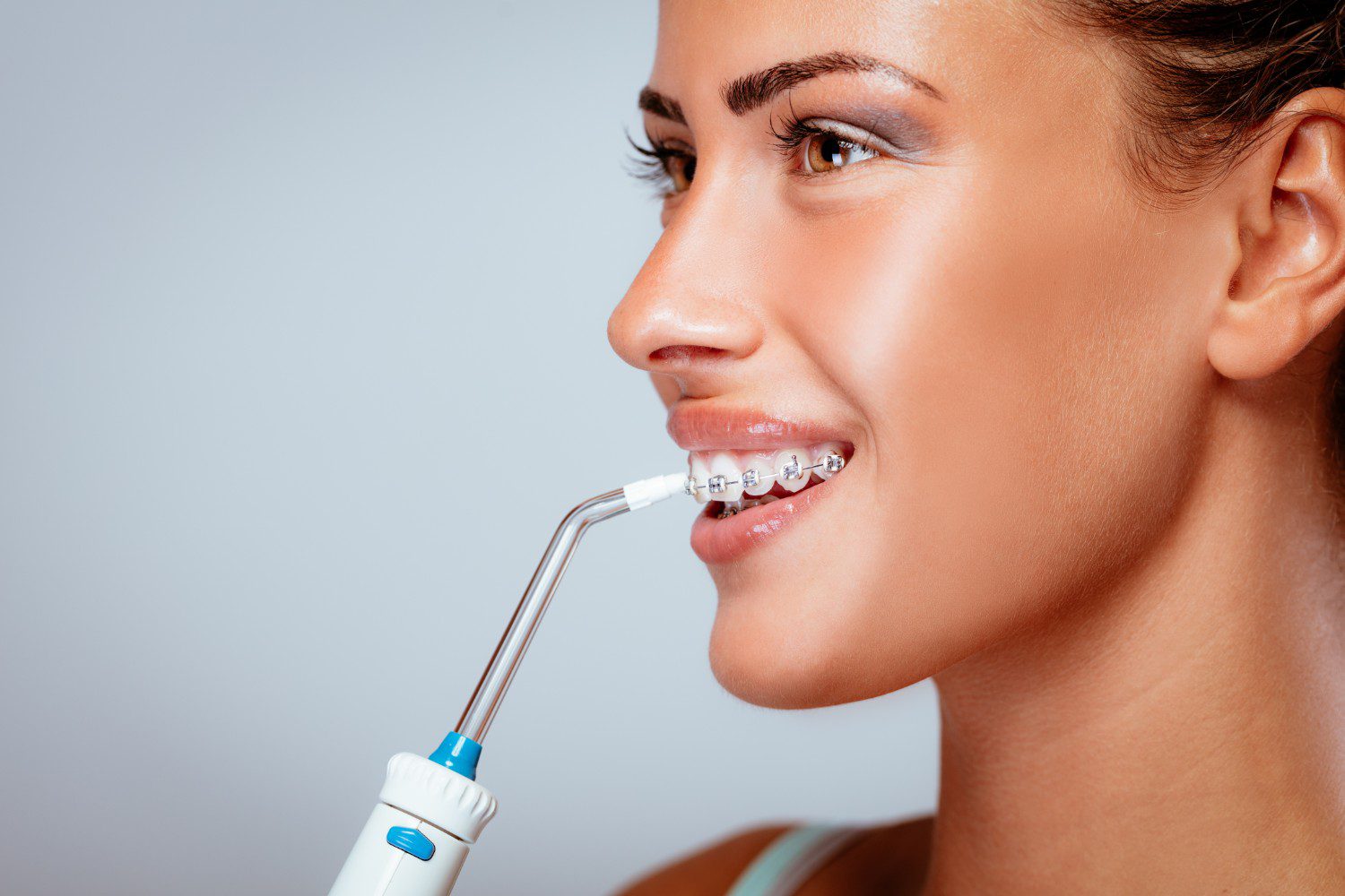 woman with braces water flossing